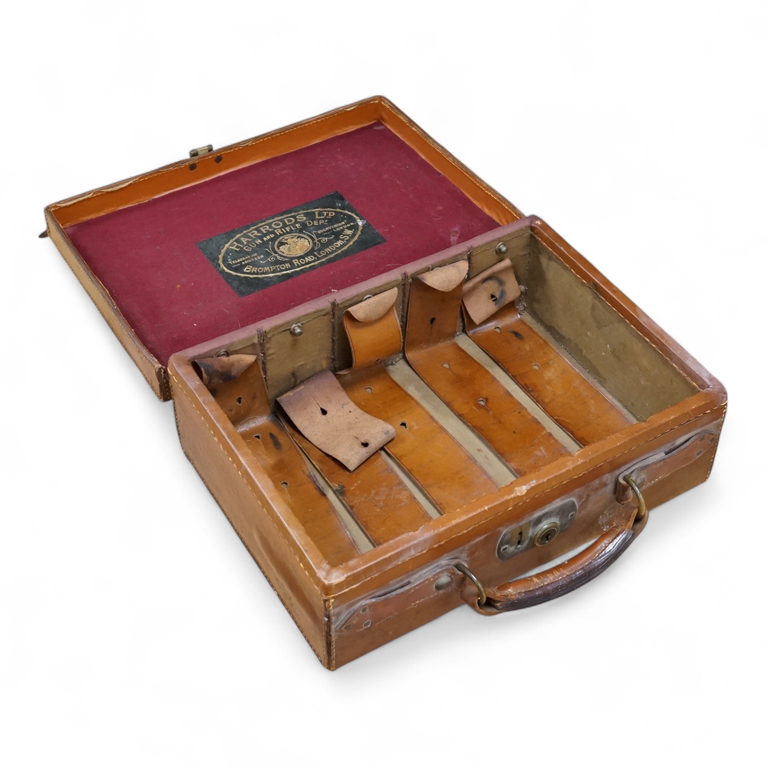 A Harrods brown leather gun/ammunition case, the lid with five leather restraining straps inside, and a good Harrods Ltd. Gun and Rifle Dept. label to the inside of the lid, dimensions; 40cm wide, 29cm high, 12.5cm deep